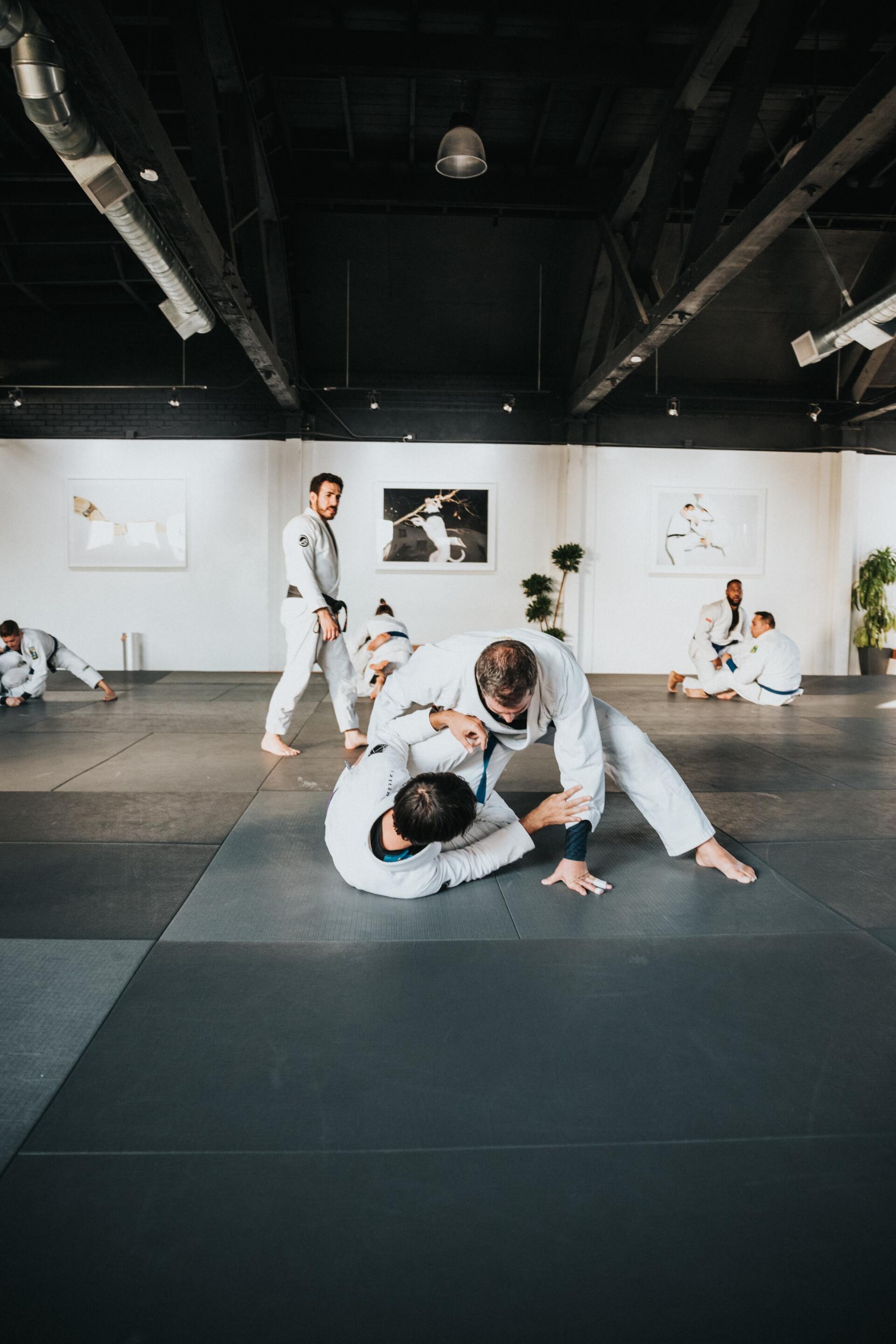 A group of men are practicing jiu jitsu in a gym.