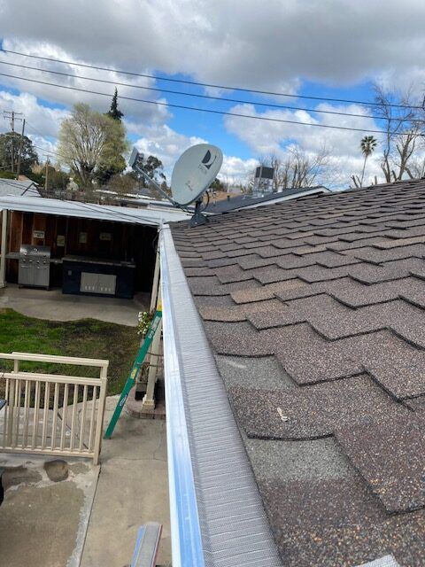 There is a satellite dish on the roof of a house.