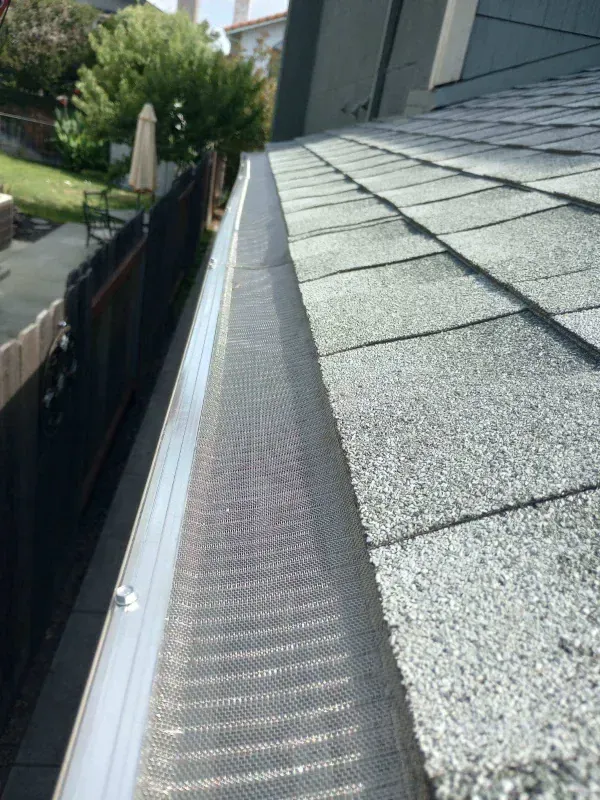 A close up of a gutter on the side of a roof.