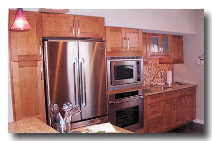 Modern kitchen with stainless steel appliances, wood cabinets, and a tiled backsplash