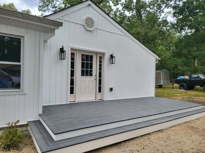 White building with double doors and a gray accessibility ramp leading to the entrance