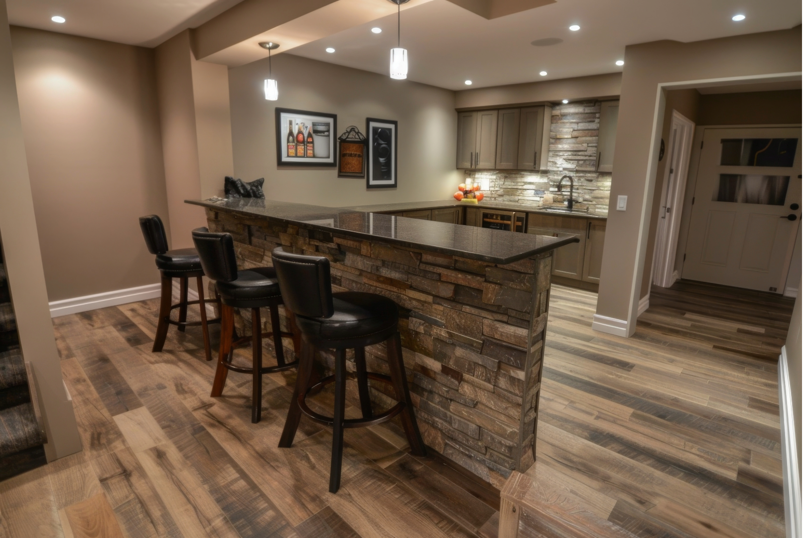 Modern kitchen with stone island, bar stools, wood floors, and recessed lighting