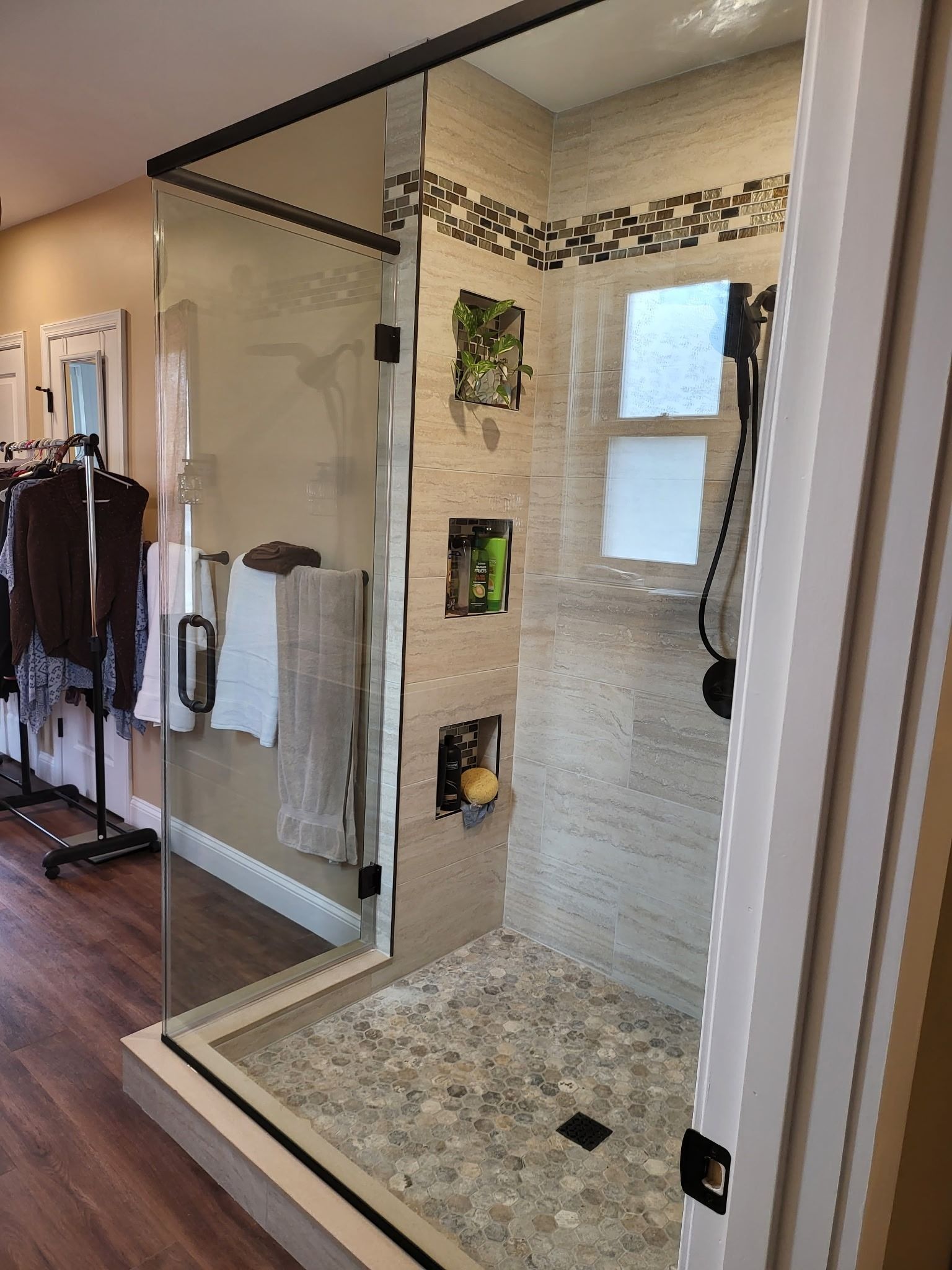 Modern bathroom with glass shower, beige tile, and a stone shower floor