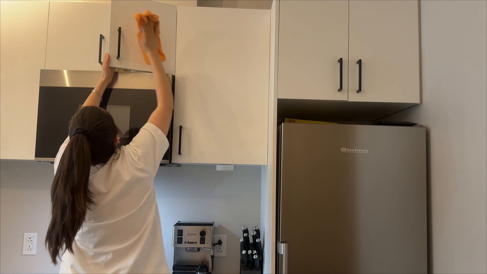 Professional cleaner dusting and making beds during a standard apartment cleaning in LIC Queens