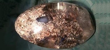 Una grande roccia è appoggiata su un panno verde su un tavolo.