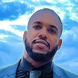 A man with a beard is wearing a suit and tie.