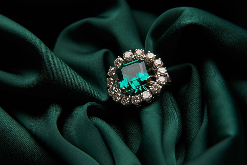 Emerald Ring With Surrounding Diamonds On Emerald Green Satin — K. Smith & Son Jewellers In Caloundra, QLD