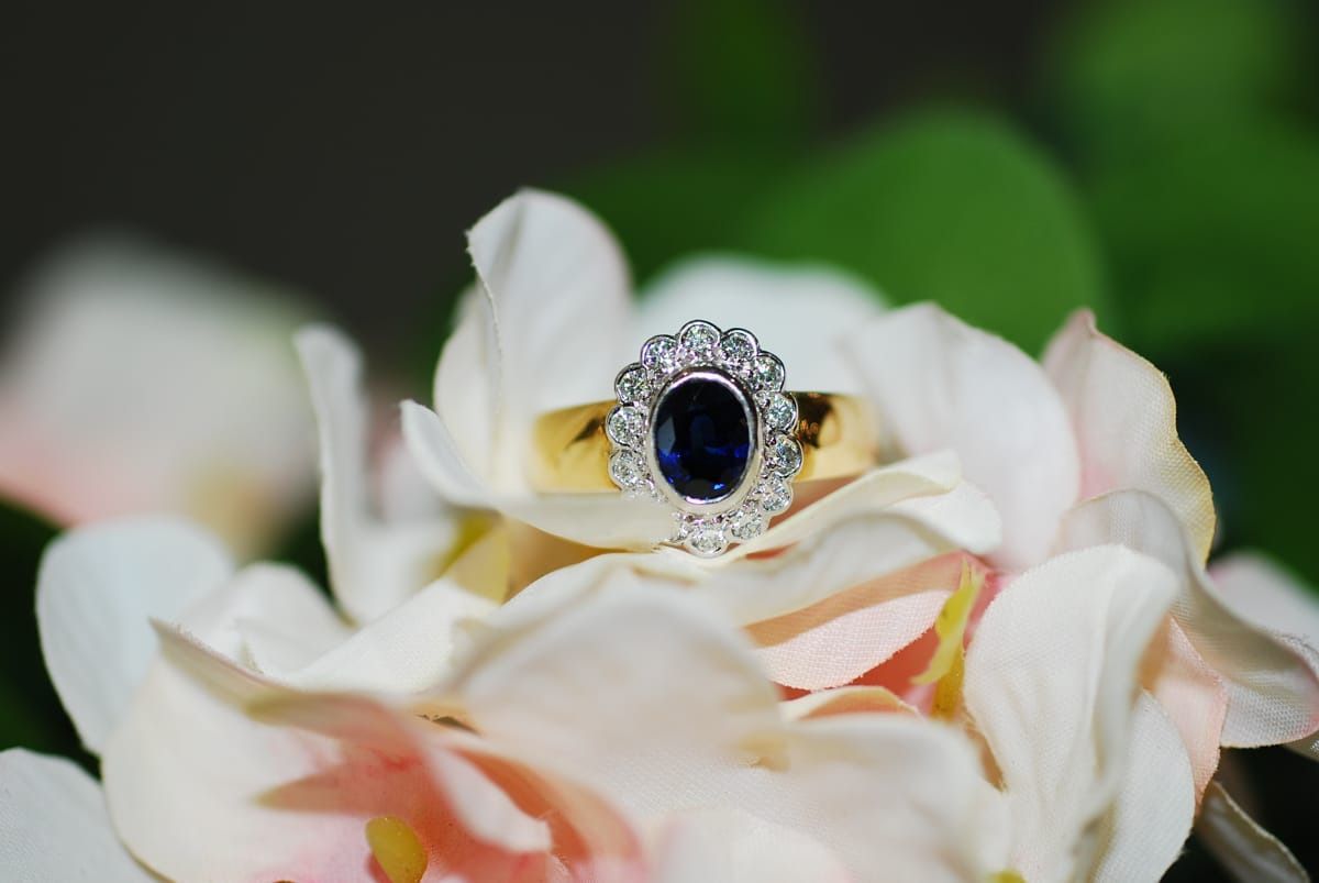 Gold Ring with Oval Blue Gemstone and Diamond Halo, Set on Pink and White Flower Petals — K. Smith & Son Jewellers In Caloundra, QLD
