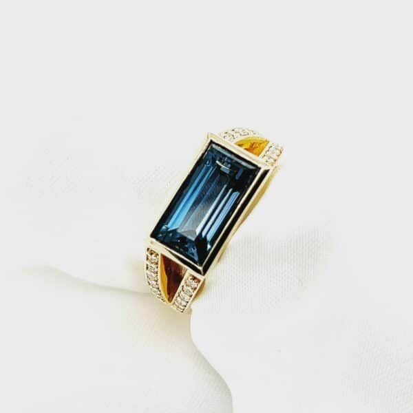 Close-up of four gold and diamond rings stacked on a white, textured strap — K. Smith & Son Jewellers In Caloundra, QLD