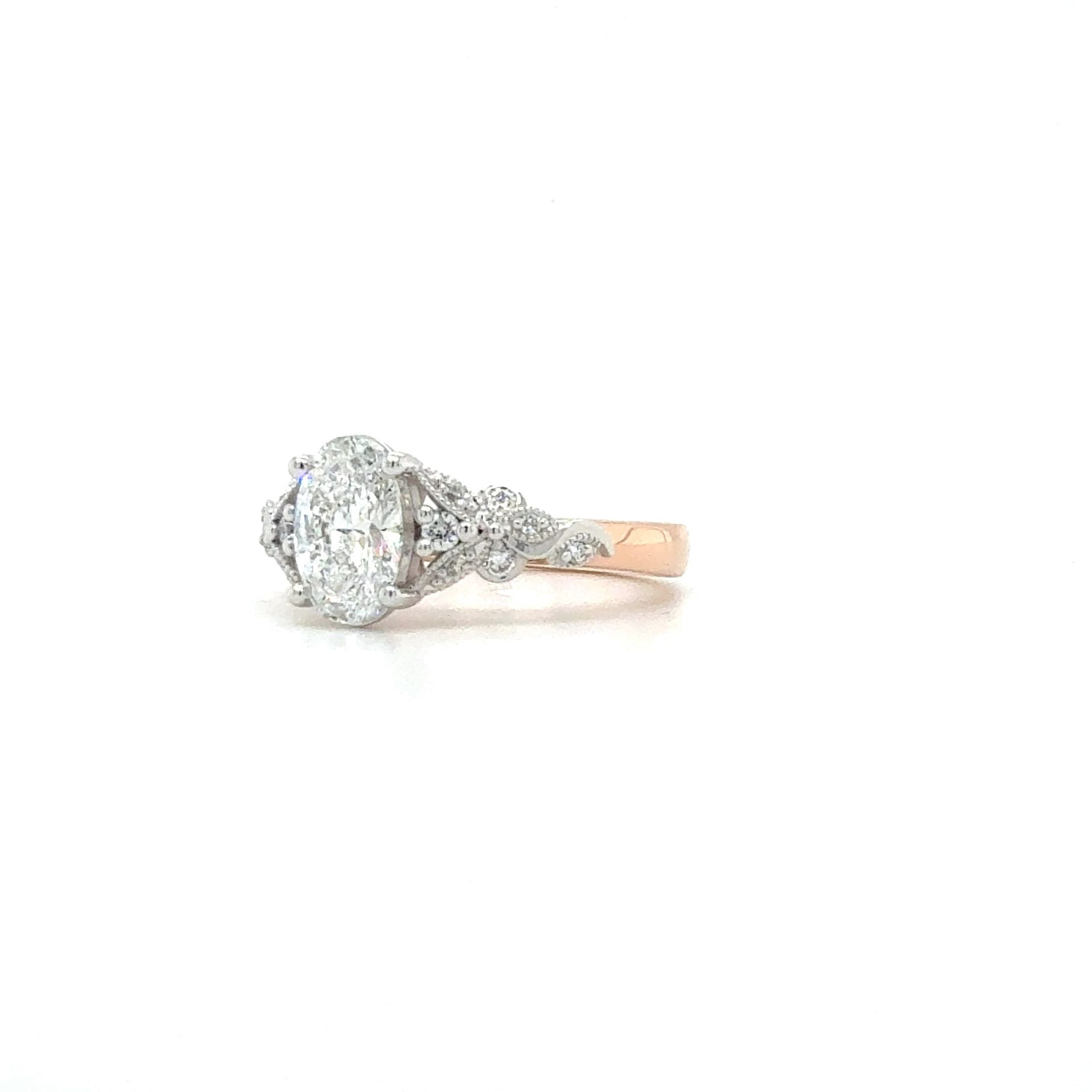 Diamond ring with an oval center stone and smaller side stones, set on a gold band — K. Smith & Son Jewellers In Caloundra, QLD