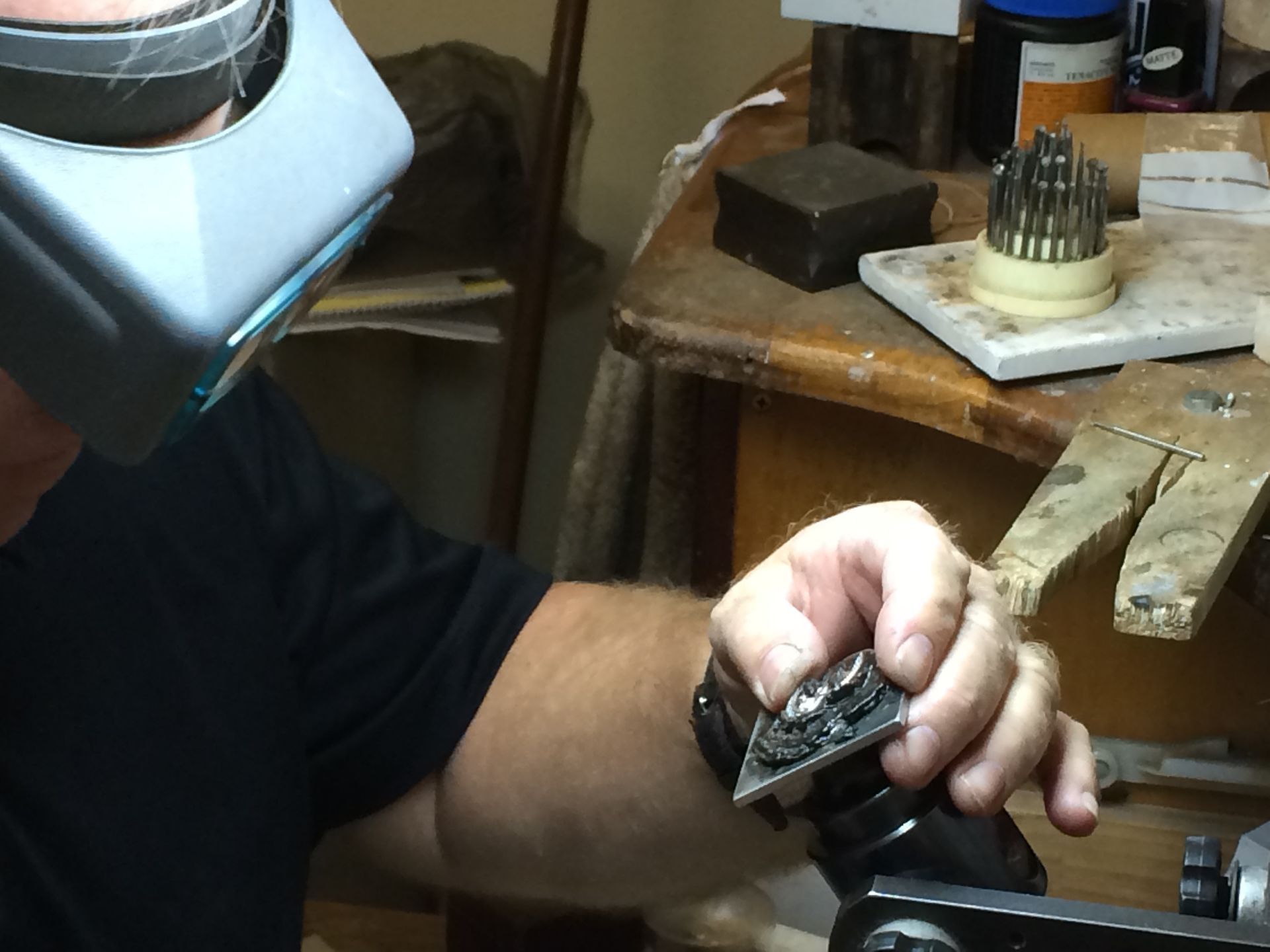 Person wearing magnifying visor working on a metal object at a workbench, close-up — K. Smith & Son Jewellers In Caloundra, QLD
