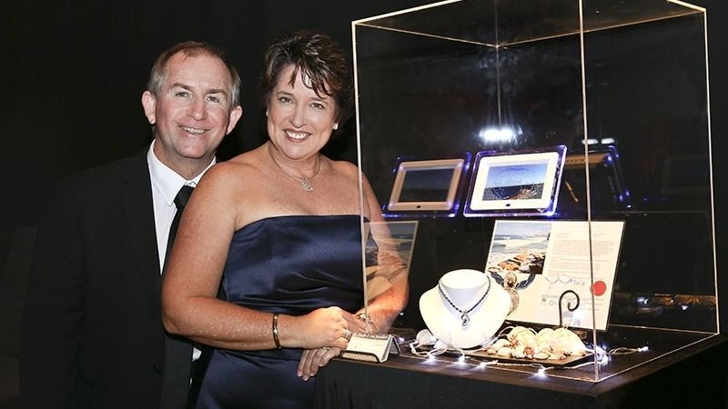A Man and a Woman Are Standing in Front of a Display Case — K. Smith & Son Jewellers In Caloundra, QLD