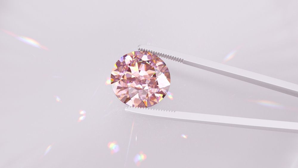 A Close Up of a Pink Diamond in Tweezers on a White Surface — K. Smith & Son Jewellers In Caloundra, QLD