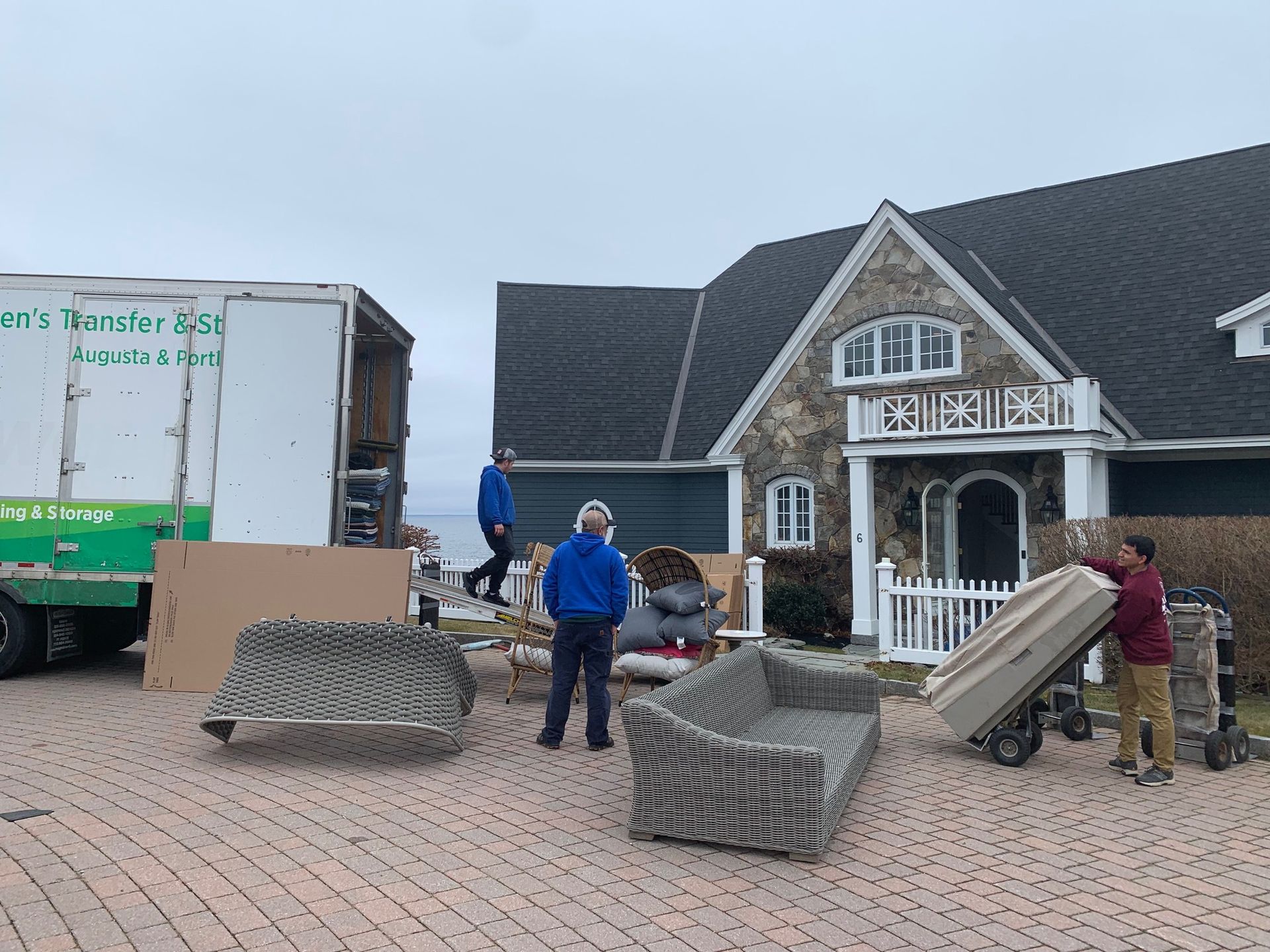 A group of people are moving furniture into a house.