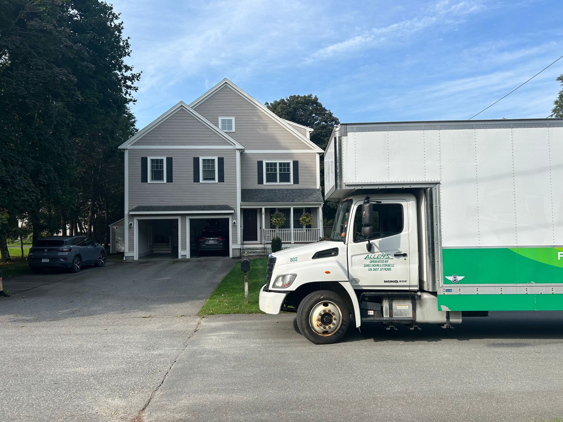 A moving truck is parked in front of a house