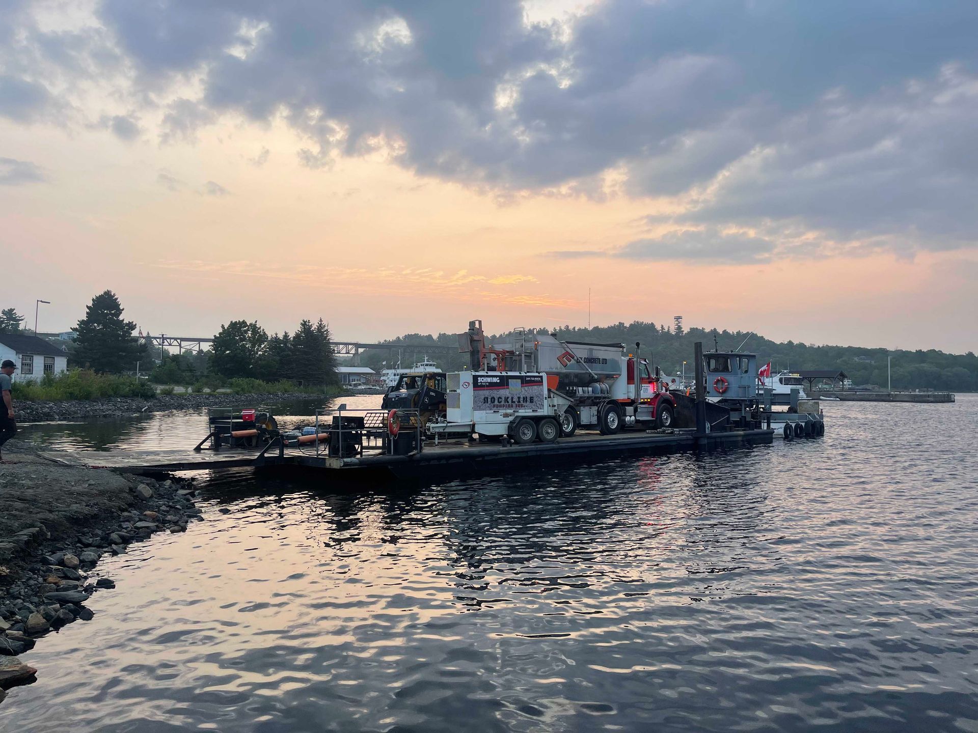 Ferry dock at dusk on calm water under a cloudy pink-blue sky
