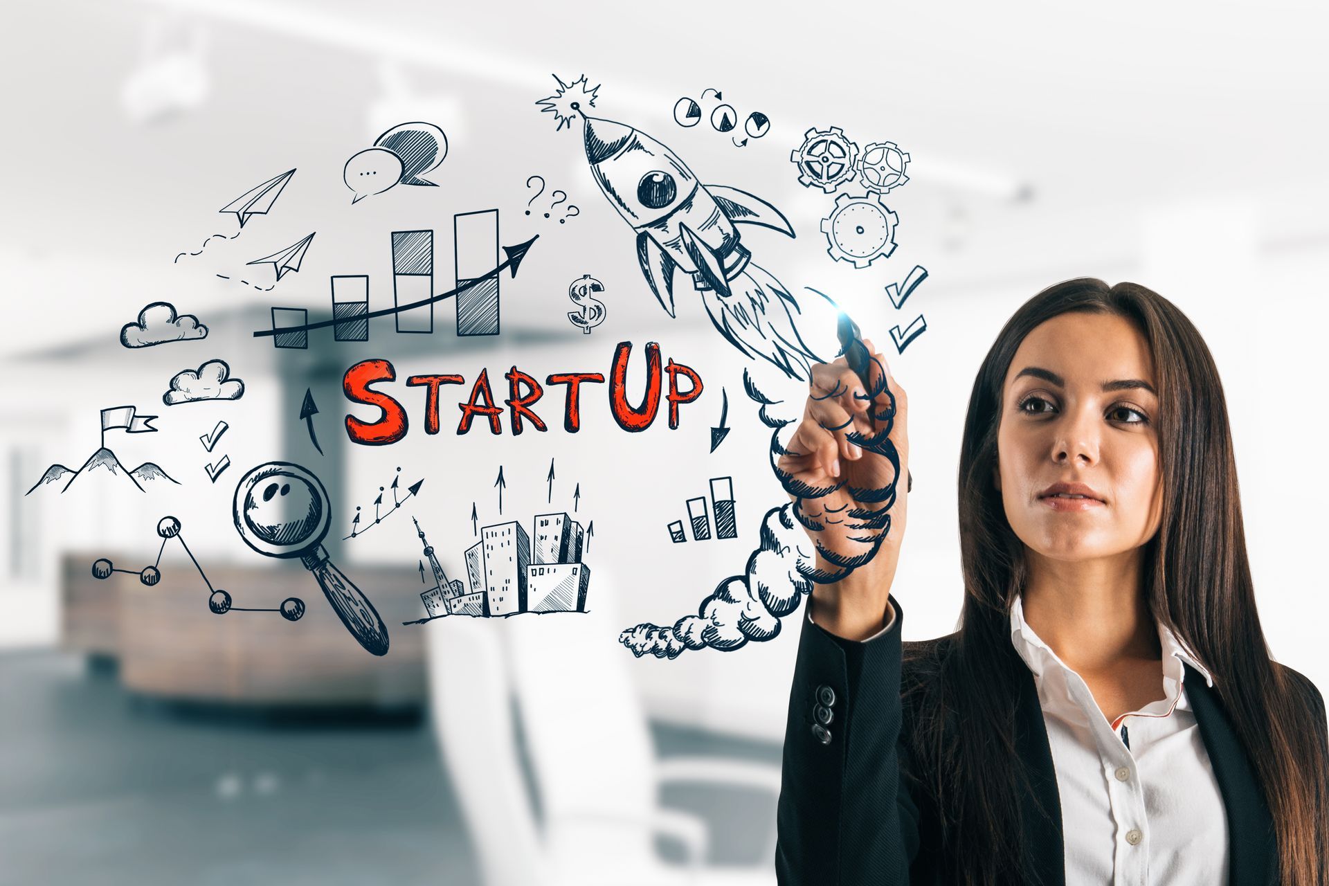 A woman writing on a glass wall with illustrations of a startup plan