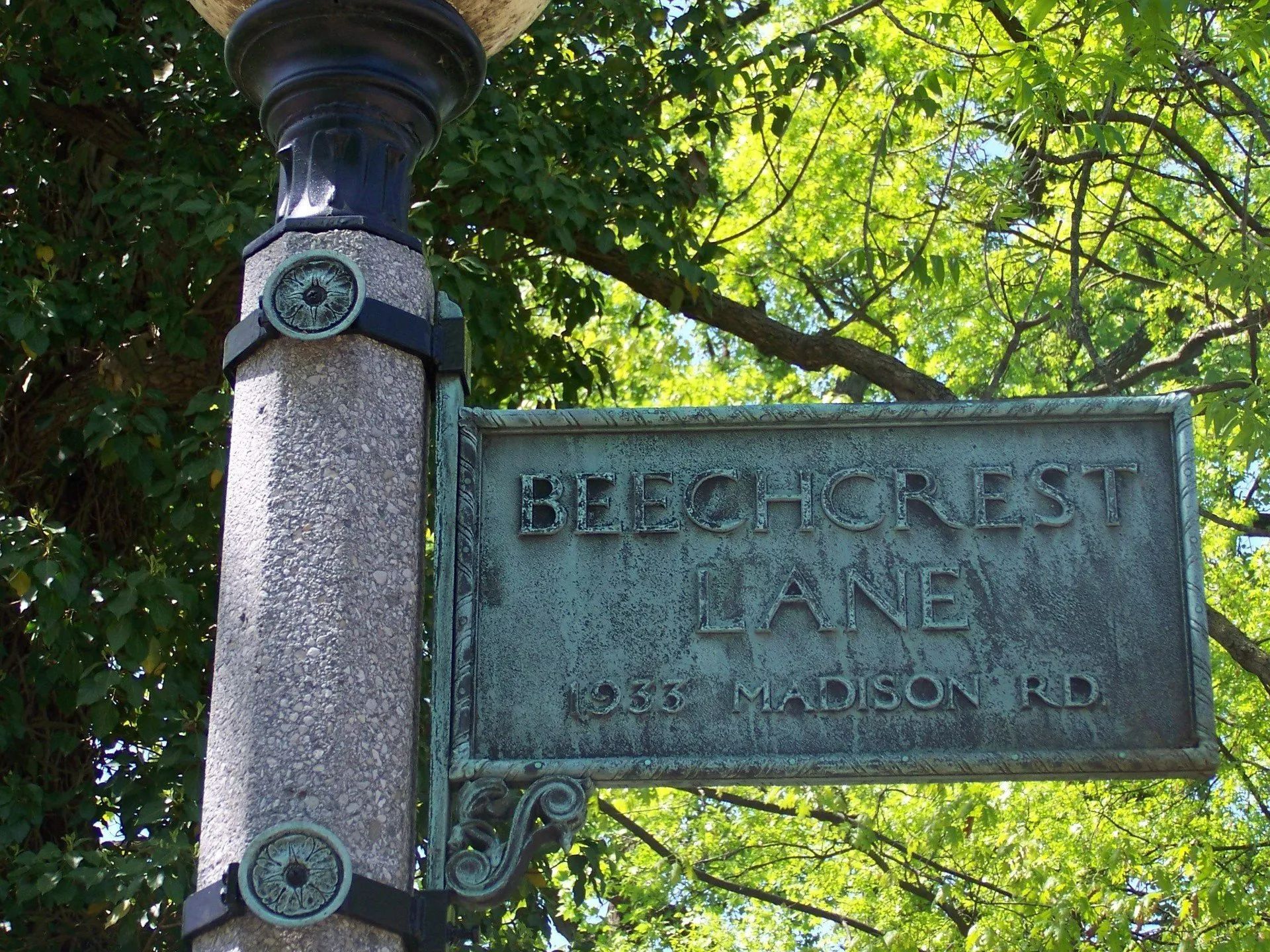 Street sign for Beechcrest Lane on a light pole, green patina, York-Madison Rd.