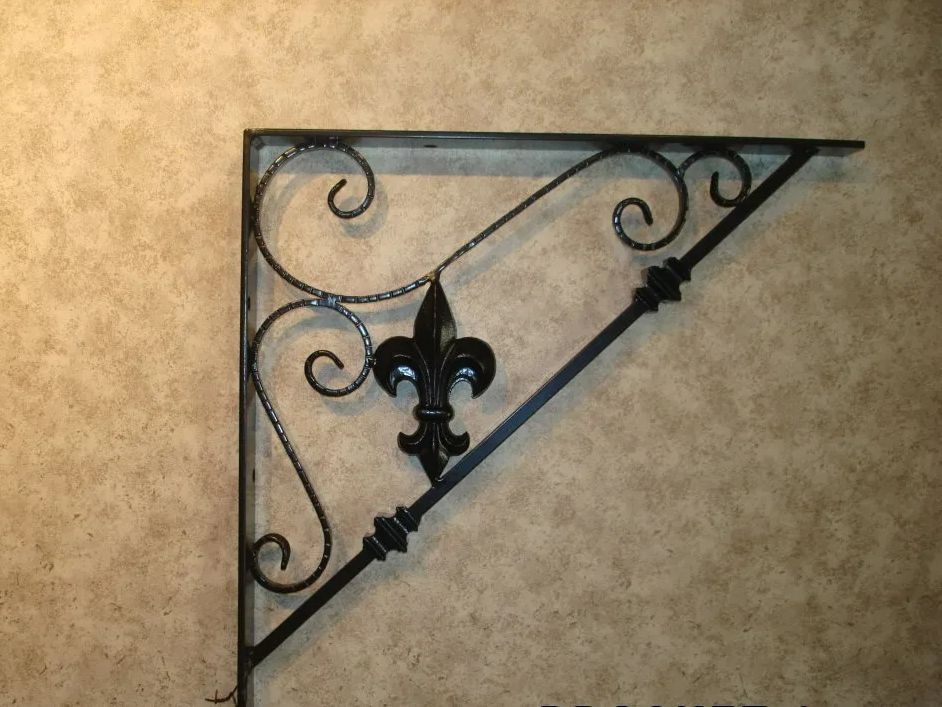 Black wrought iron corner shelf bracket with fleur-de-lis detail on textured wall.