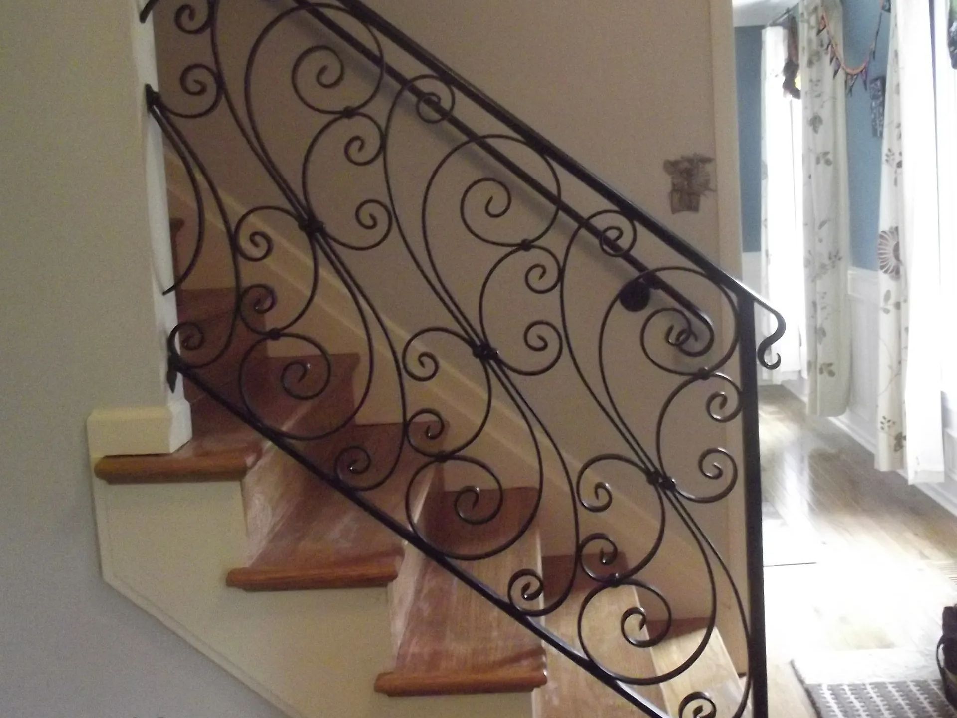 Black wrought iron stair railing with ornate scrollwork.