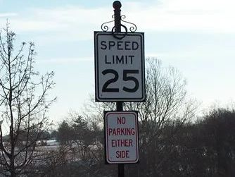Speed limit sign, 25 mph, with a no parking sign below it.