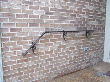 Black metal handrail on brick wall, providing support.