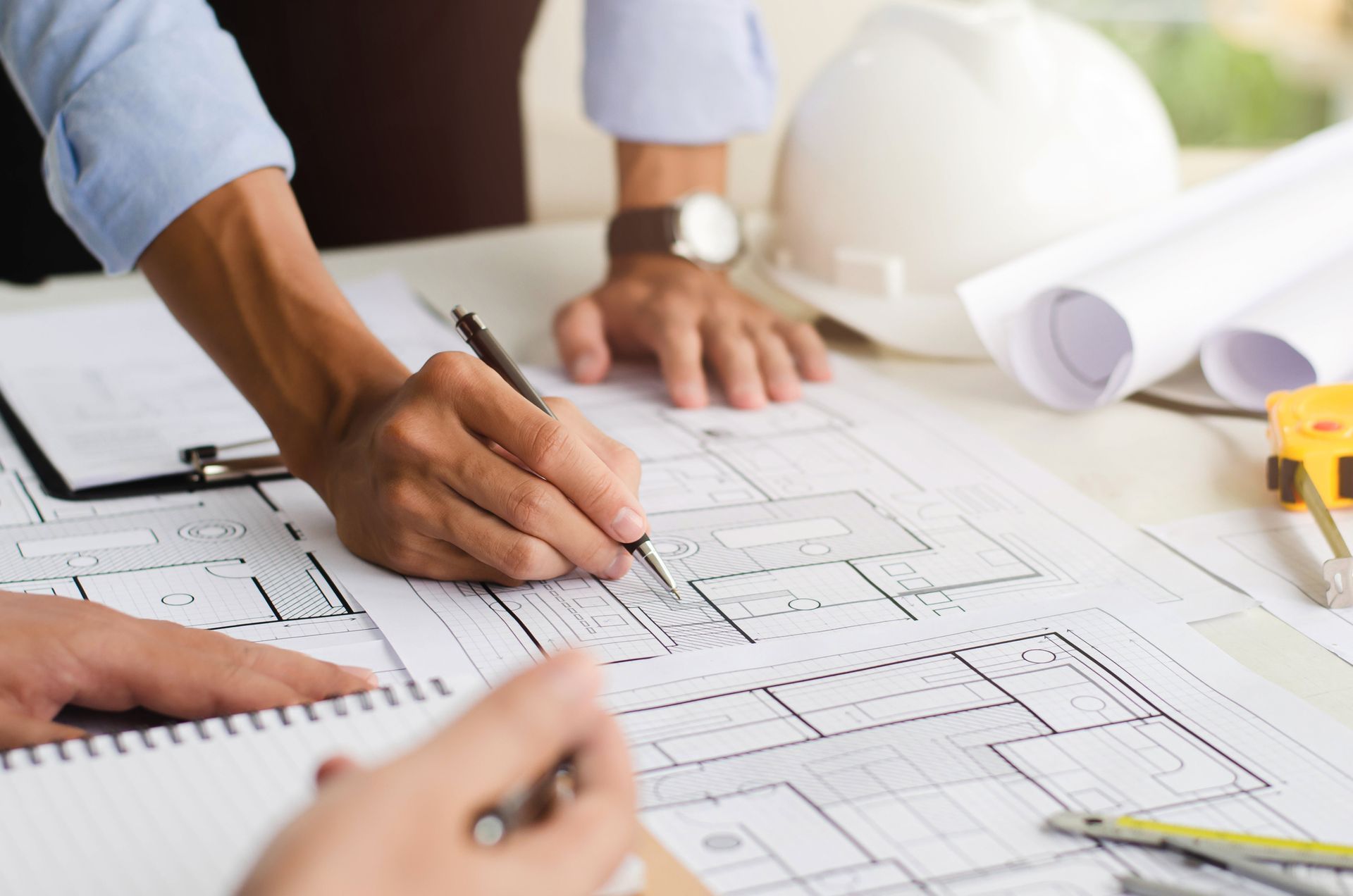 A group of people are working on a blueprint of a house.