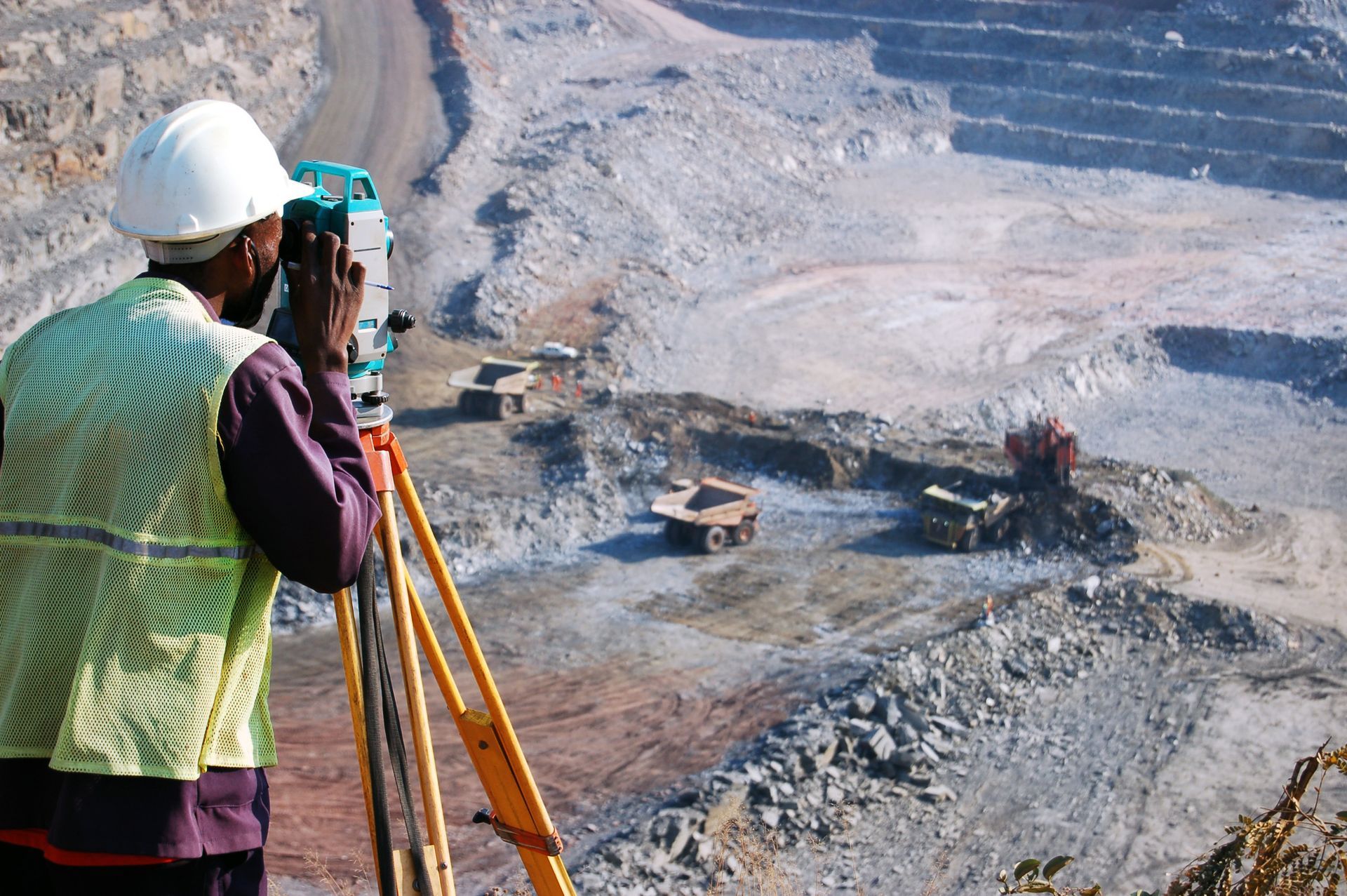 A man wearing a hard hat is taking a picture of a construction site.