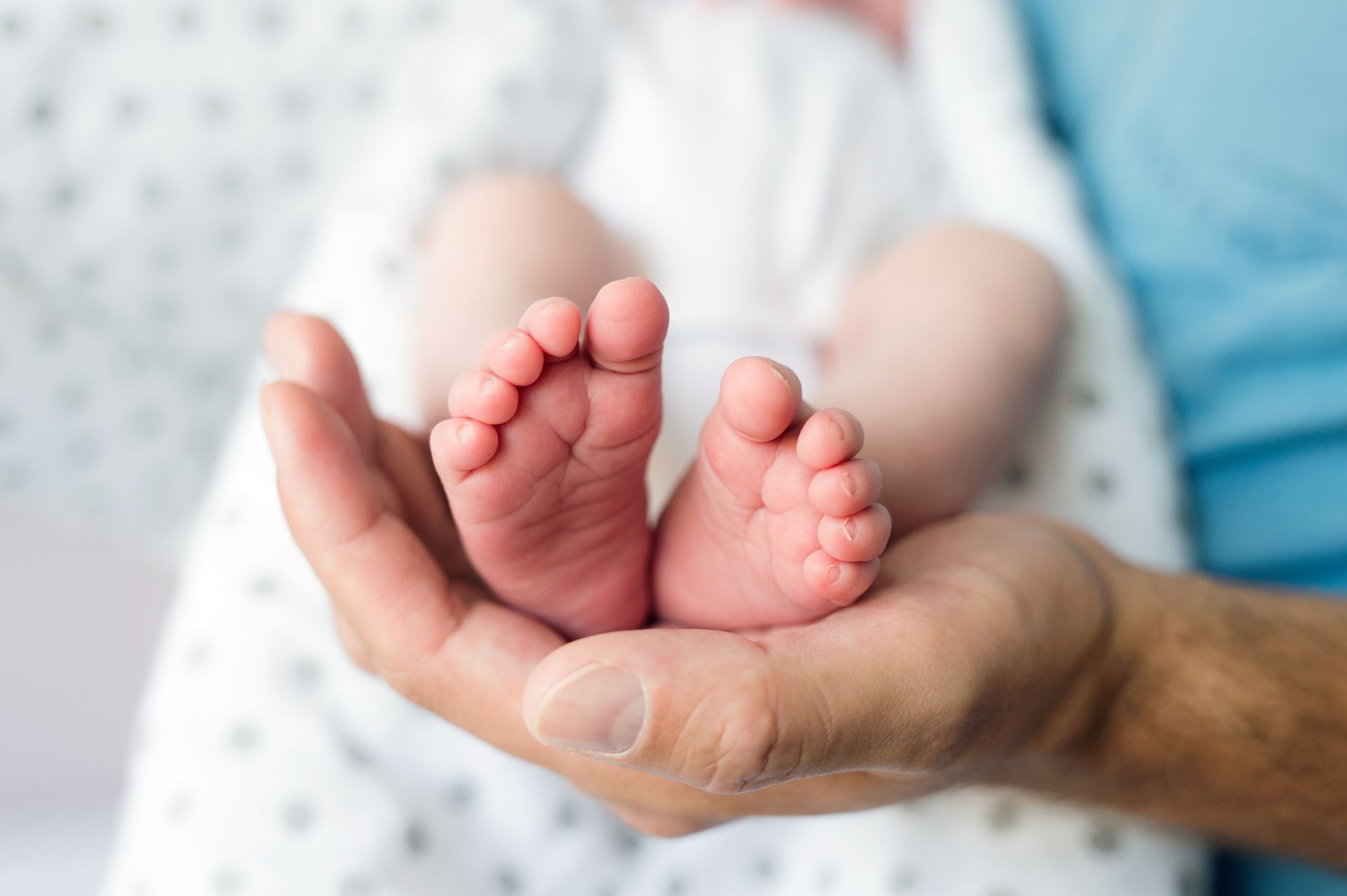 Parent holding newborn baby's tiny feet