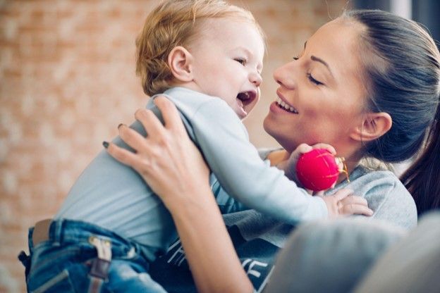 A woman is holding a baby in her arms.