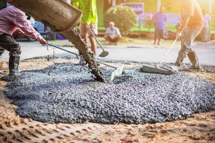 Workers pouring wet concrete at a construction site