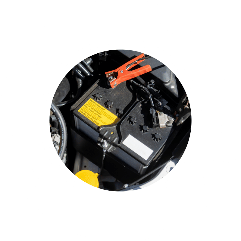 Vehicle battery with jumper cable attached, highlighting battery testing, charging, and replacement services.