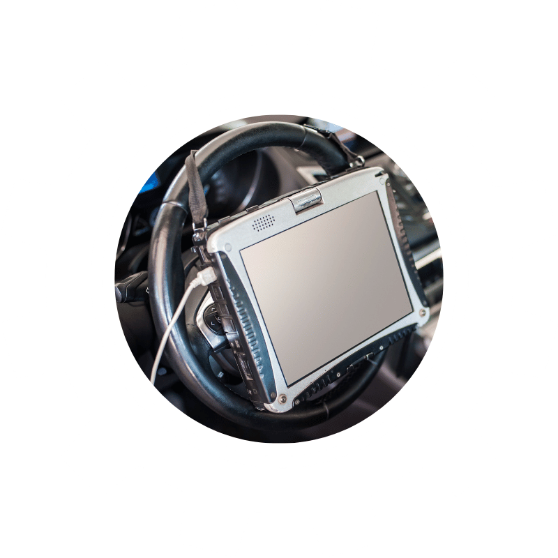 Automotive diagnostic tablet connected inside a vehicle, used to identify warning lights, faults, and performance issues.