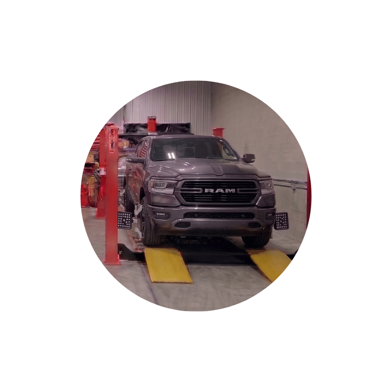 Gray Ram pickup truck secured on professional alignment equipment to improve tire life and road handling.