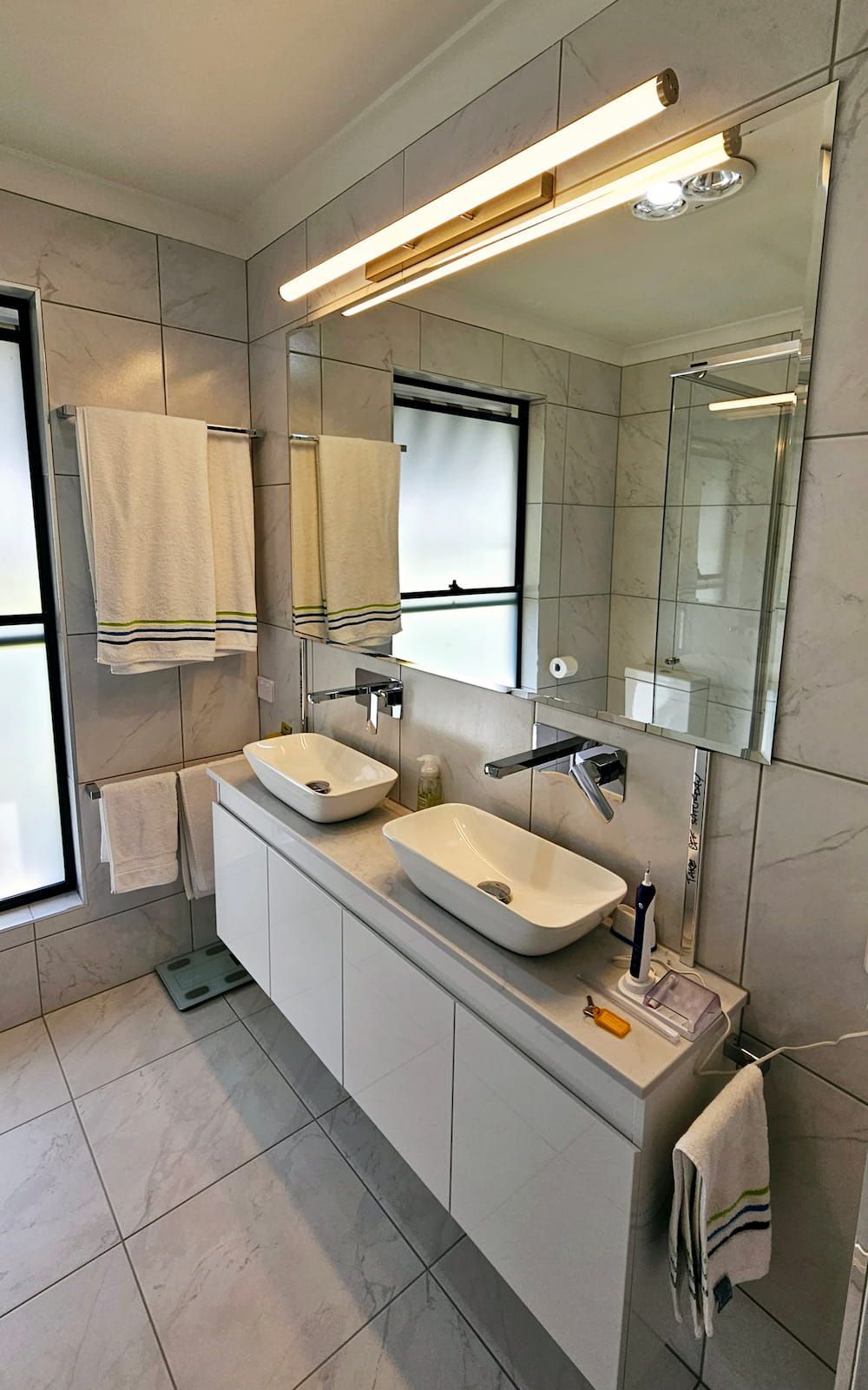 A Bathroom With Two Sinks And A Large Mirror — Mobile Shower Door Doctor In Mountain Creek, QLD