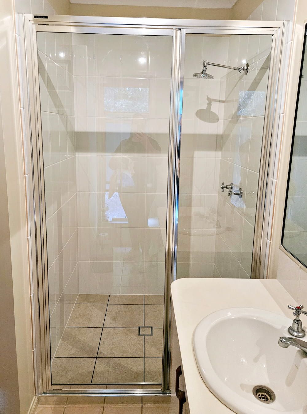 A Bathroom With A Shower, Sink And Mirror — Mobile Shower Door Doctor In Mountain Creek, QLD