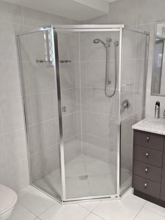 A Bathroom With A Shower Stall, Toilet, Sink And Mirror — Mobile Shower Door Doctor In Mountain Creek, QLD