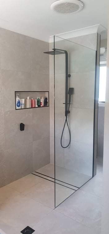 A Bathroom With A Walk In Shower With A Black Shower Head — Mobile Shower Door Doctor In Mountain Creek, QLD