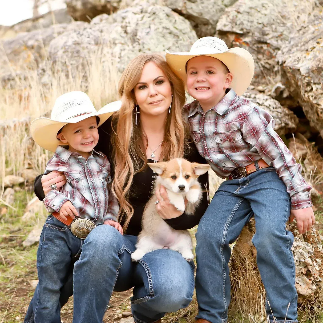 A woman and two children are posing for a picture with a dog.