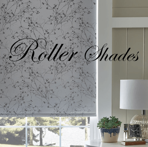 Roller shade with gray floral pattern, partially covering a window in a room with a lamp and decor.