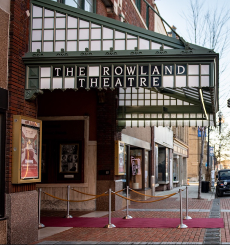 The Rowland Theatre entrance with red carpet, marquee, and brick facade.