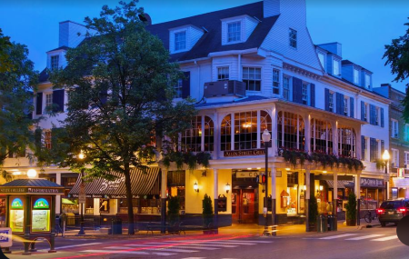 Elegant multi-story building with awnings, street lights, and a restaurant; evening setting.