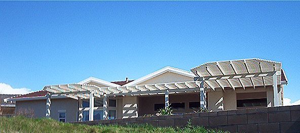 House with pergola and blue sky.