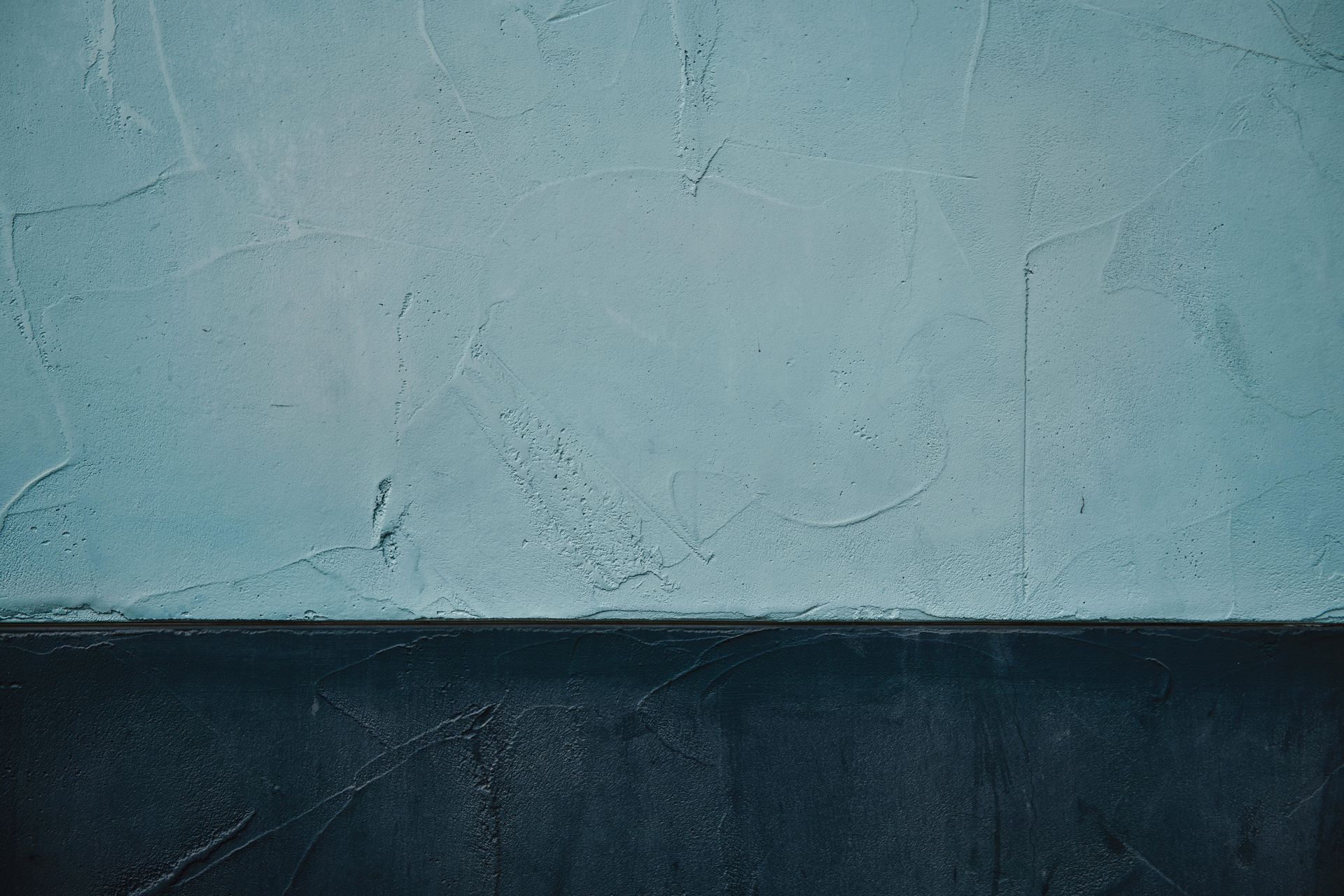 Two-toned wall: upper half light blue, lower half dark blue, textured, horizontal division.