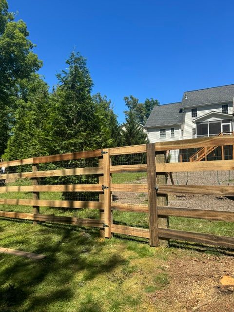A wooden fence is in front of a house — Scottsville, Va — Pbr Grounds Llc
