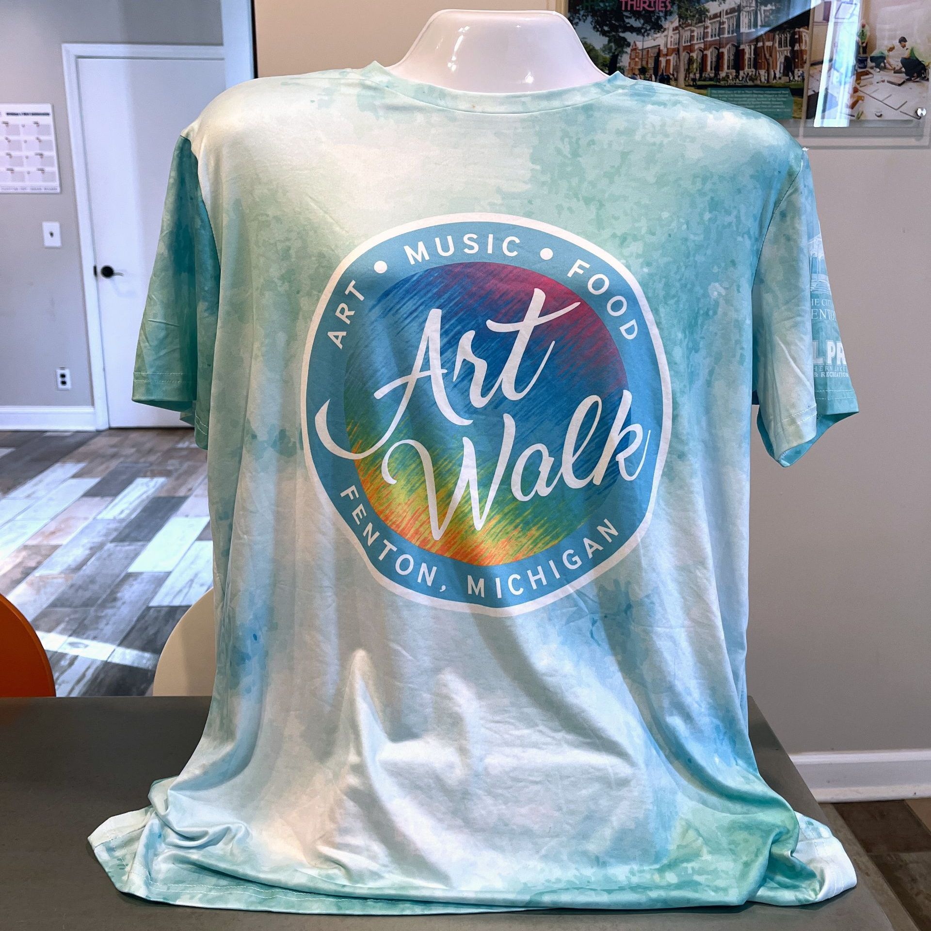 Turquoise tie-dye T-shirt on mannequin with circular Art Walk logo reading “Arts Music Food” and “Benton Harbor Michigan”