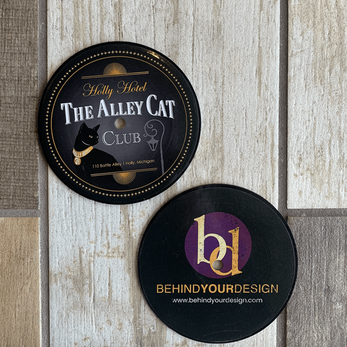 The alley cat club is advertised on these coasters