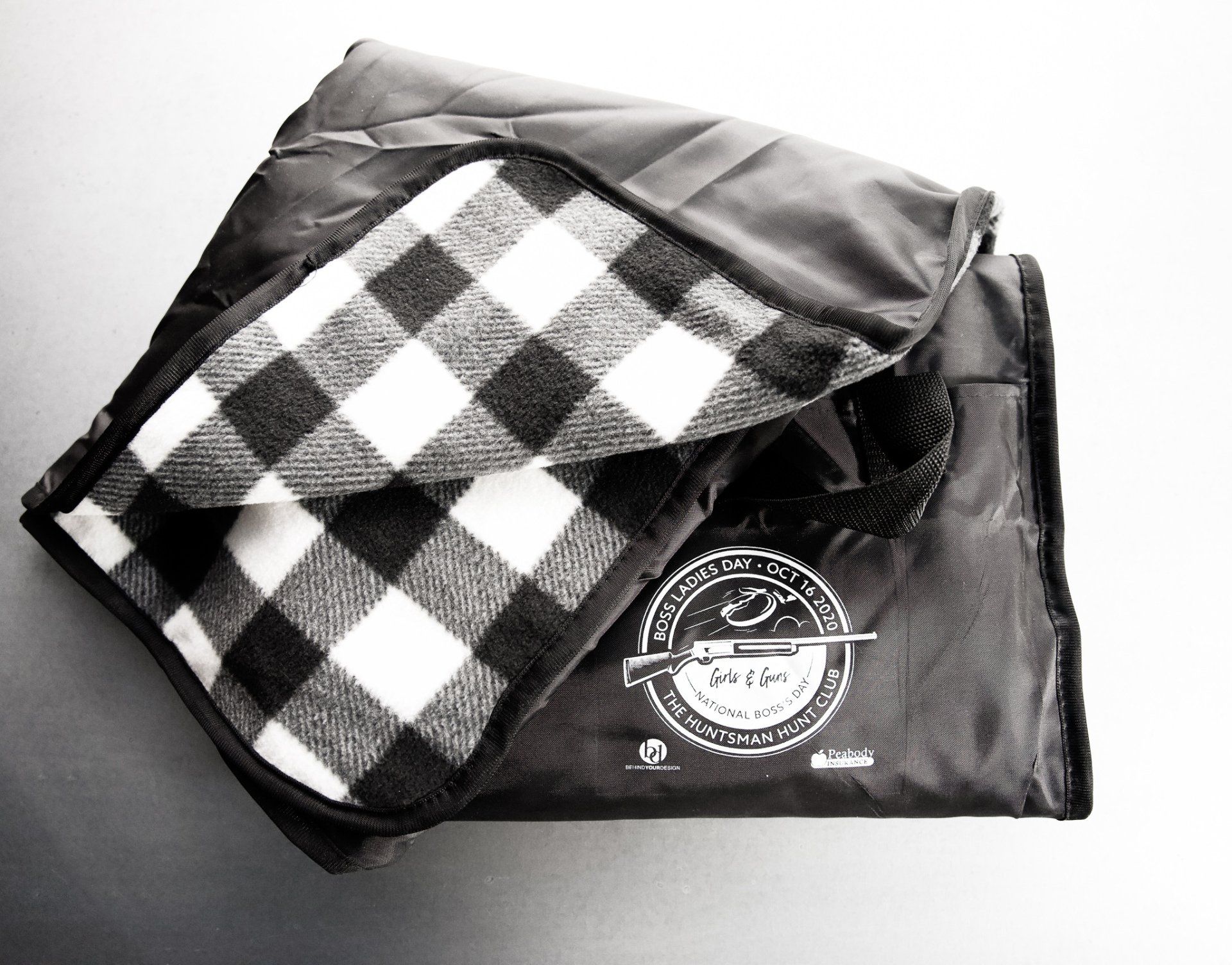 A black and white plaid blanket with a logo on it