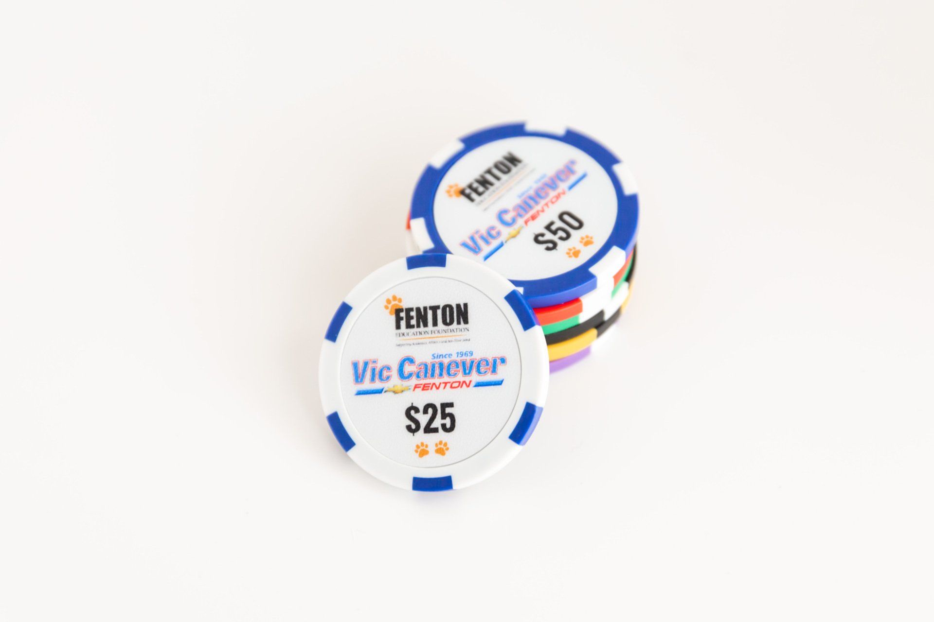 Two poker chips are stacked on top of each other on a white surface.