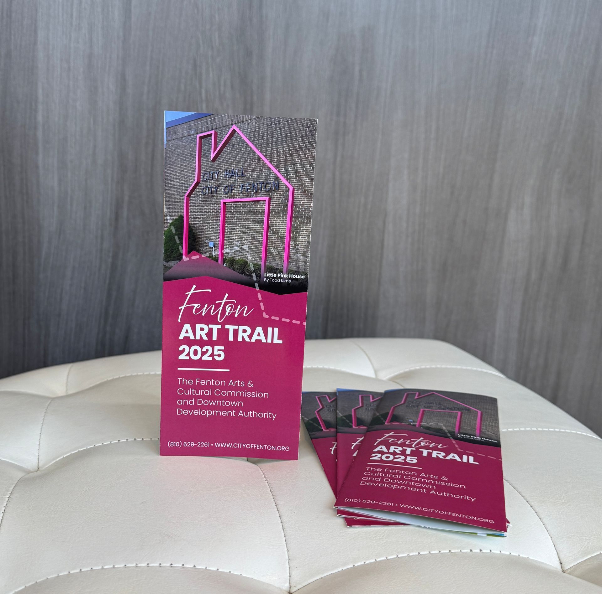 A brochure for the art trail 2025 sits on a white ottoman